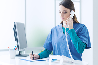 nurse talking on the phone writing on paper